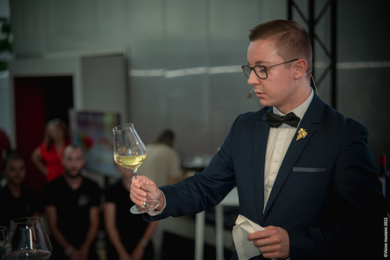Yoann ROËSS décrit de façon détaillée un vin blanc lors du concours VINOCITÉ devant le jury et le public.